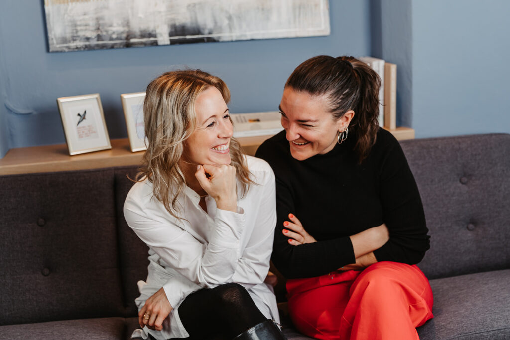 Therapeutinnen sitzen auf einer Couch und lachen