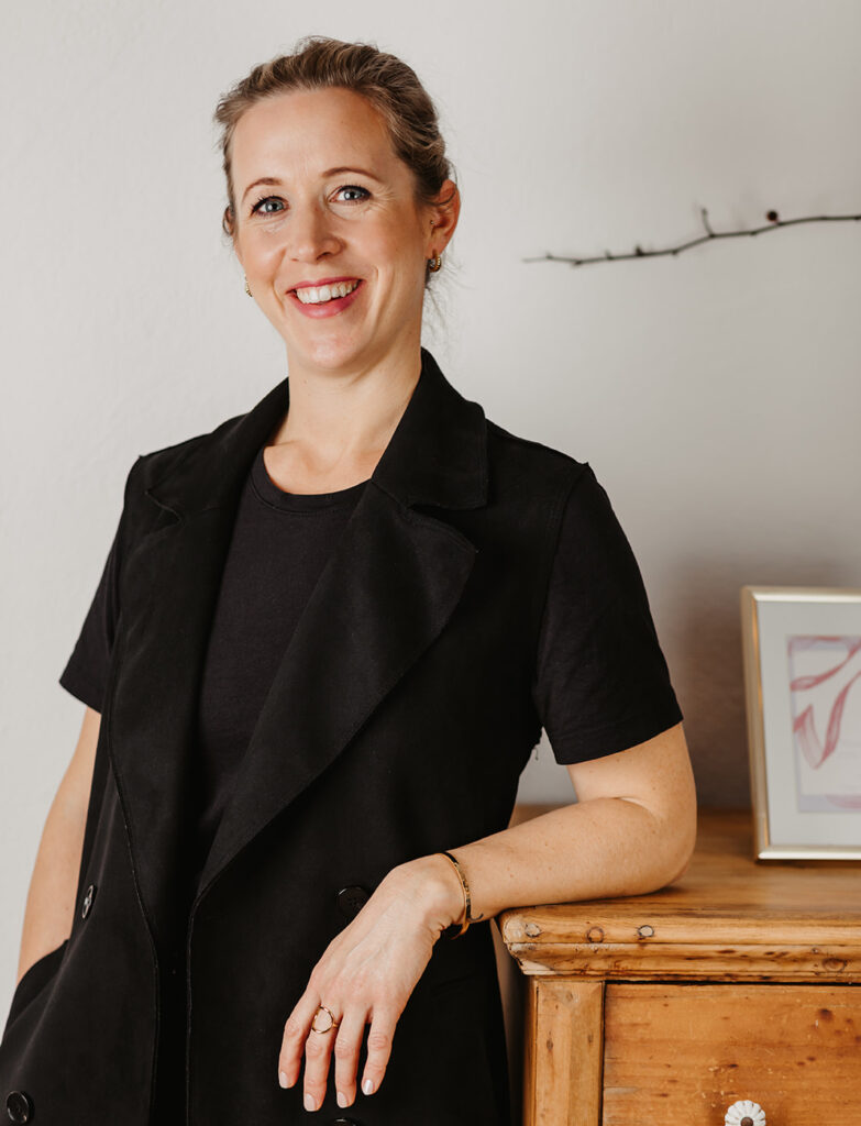 Lisa Weickl lehnt an einer Kommode und lächelt in die Kamera.