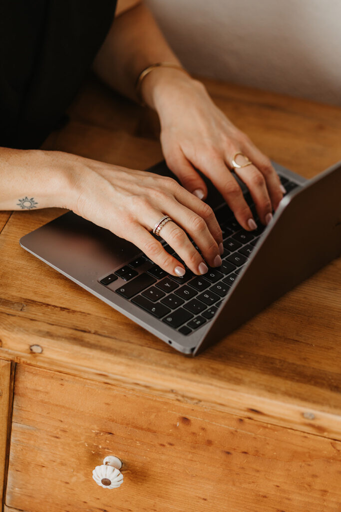Hände tippen auf einem Laptop
