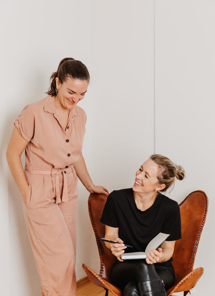 Therapeutinnen stehen und sitzen und lachen